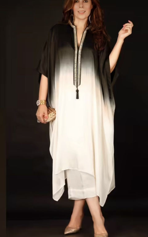 Woman wearing a gradient dress with a black and white color scheme, holding a clutch.